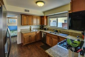 a kitchen with wooden cabinets and a large window at F-30 Small World in Anaheim