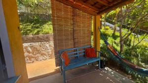 a blue bench on the porch of a house at Chalé Almar - Praia do Sagi in Baía Formosa