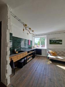 a room with a kitchen with a desk and a bed at Mākslas studija Koknesē in Koknese