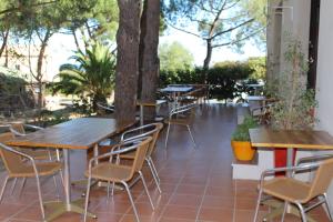 - une rangée de tables et de chaises sur la terrasse dans l'établissement Résidence Tramariccia, à Calvi