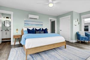a bedroom with a blue and white bed and a chair at Dog Friendly | Waterfront | Surf City, NC | 2 Master Suites | Elevator in Surf City