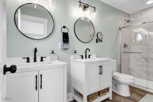 a white bathroom with two sinks and a toilet at Dog Friendly | Waterfront | Surf City, NC | 2 Master Suites | Elevator in Surf City +40 photos