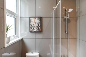 a bathroom with a shower and a toilet and a picture at South Croydon, garden maisonette, free parking, Gatwick accessible in Purley +19 photos