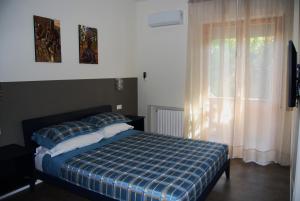 - une chambre dotée d'un lit avec une couverture tressée et une fenêtre dans l'établissement la casa di sabrina, à Francavilla al Mare