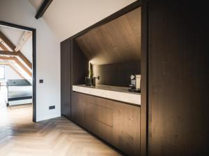 Una cocina con gabinetes de madera y encimera. en Suite Ouddorp - 2 pers, en Ouddorp