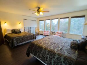 a hotel room with two beds and a ceiling fan at Hidden Oasis Near Downtown in Eureka Springs +39 photos