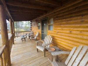 un porche de una cabaña de madera con sillas en Wild Plum Cabin No. 2, en Eureka Springs