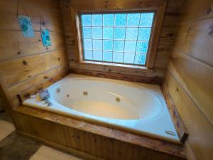 bañera grande en una habitación con ventana en Wild Plum Cabin No. 2, en Eureka Springs 10 fotos más