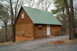 a large wooden barn with a green roof at Wild Plum Cabin No. 3 in Eureka Springs