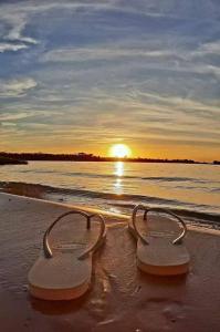 due paia di infradito sulla spiaggia al tramonto di CARTAGENA MAR a pocas cuadras a Estación El Salto