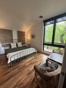 Un dormitorio con una cama y una ventana grande. en The Ozark Deck House, en Eureka Springs