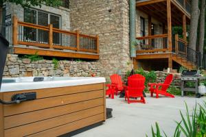a patio with red chairs and a hot tub at Entire Building at 151 Spring in Eureka Springs