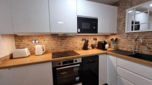 a kitchen with white cabinets and a black dishwasher at Boxford Lodge - Serviced Apartment in Bracknell, near Ascot & Windsor, Free Parking in Bracknell