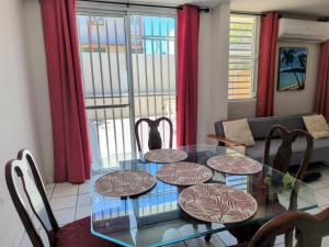 a glass dining room table with four chairs and a couch at Ginger House in Rincon
