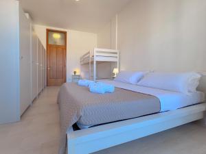 a white bedroom with a large bed with blue sheets at Vittorio Veneto - Spacious and Bright by Host Hero in Civitanova Marche