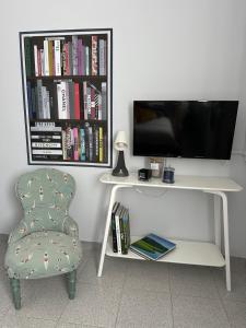 a white desk with a tv and a chair at Hotel Mambo in Laigueglia