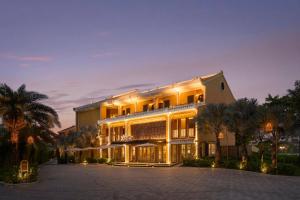 a large building with palm trees in front of it at Moire Hoi An, Vignette Collection by IHG in Hoi An