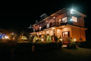 a building with christmas lights in front of it at night at Corbett Nature Walk - Forest View Swimming Pool in Rāmnagar