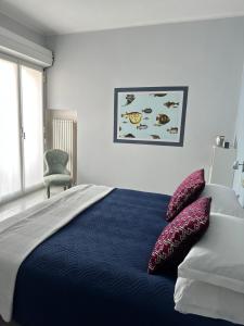 a bedroom with a bed with two pillows on it at Hotel Mambo in Laigueglia