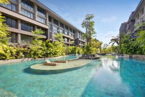 a swimming pool in front of a building at Anagata Paradiso Bali in Nusa Dua
