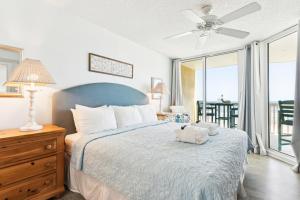 a bedroom with a bed with a blue headboard at 214 COV - Go Fly a Kite - Oceanfront Condo - 2 Pools in Folly Beach +63 photos