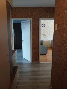 a hallway with a door and a room with a clock at Buto nuama in Mažeikiai +2 photos