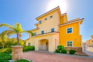 a yellow house with a palm tree in front of it at F-56 Winnie the Poohs Treehouse in Anaheim