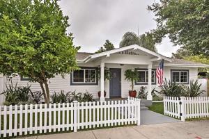 ein weißes Haus mit einem Zaun und einer amerikanischen Flagge in der Unterkunft F-55 Donald Ducks Cottage in Anaheim
