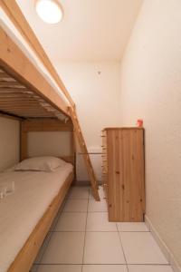 a bedroom with two bunk beds and a wooden cabinet at L'Athéna By Tranquil at Home in Pornichet