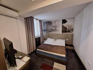 a hotel room with a bed and a television at Hotel Boutique Bristol in Sarajevo