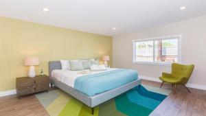 a bedroom with a bed and a green chair at F-52 Trenton II in Anaheim +16 photos