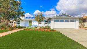 a house with a white garage and a green lawn at F-52 Trenton II in Anaheim