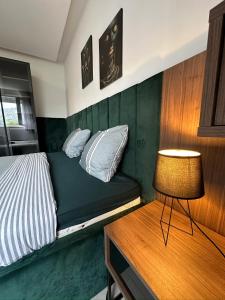 Un dormitorio con una cama y una mesa con una lámpara. en Palma, en Mostar 13 fotos más