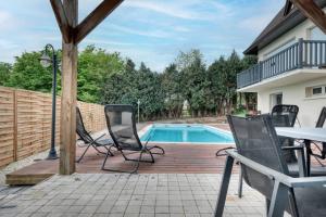 a deck with chairs and a swimming pool at Maison ANA in Équemauville