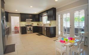 a kitchen with black cabinets and a table with chairs at F-16 Pirates Lair in Anaheim