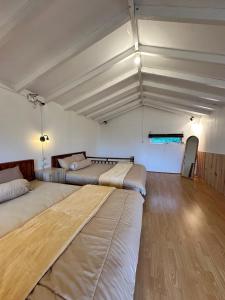 two beds in a large room with wooden floors at Aruna Dieng in Dieng +4 photos