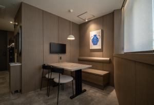 a room with a table and chairs and a television at Extay Dongdaemun in Seoul