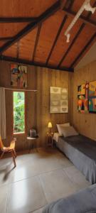 ein Schlafzimmer mit einem Bett in einem Zimmer mit Holzwänden in der Unterkunft Casa Cor Tiradentes in Tiradentes