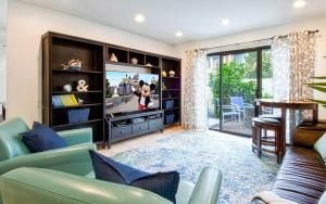 a living room with a couch and a tv at Tron by Funtierland Vacation Rentals in Anaheim