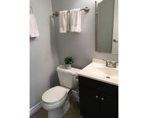 a bathroom with a white toilet and a sink at Arendelle by Funtierland Vacation Rentals in Anaheim +19 photos