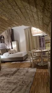 a living room with a bed and a table at La Caverna - Bari Vecchia, Fronte Mare in Bari