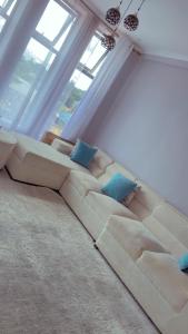 a living room with a large couch with blue pillows at QD Apartment in Arusha