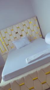 a bed with a yellow and white bed frame at QD Apartment in Arusha