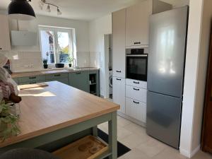 eine Küche mit einem Kühlschrank aus Edelstahl und einem Tisch in der Unterkunft Seestern in Dassow