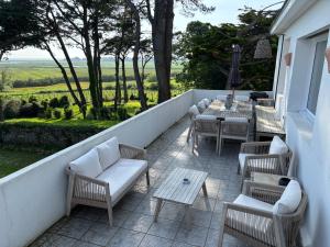 a patio with chairs and tables on a balcony at Villa Vieilles Vignes vue mer in Billiers