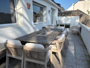 a wooden table and chairs on a patio at Villa Vieilles Vignes vue mer in Billiers