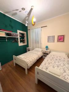 two beds in a room with green walls at Visilo Stone House in Pučišća