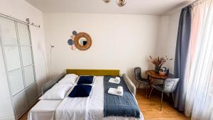 a bedroom with a bed and a table and a mirror at Green House Studios in Braşov
