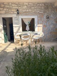 a table and two chairs in front of a building at Visilo Heritage Stone House - A 300-year-old Legacy in the Heart of Pučišća in Pučišća +51 photos