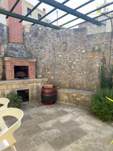a patio with a stone wall and a fireplace at Visilo Heritage Stone House - A 300-year-old Legacy in the Heart of Pučišća in Pučišća